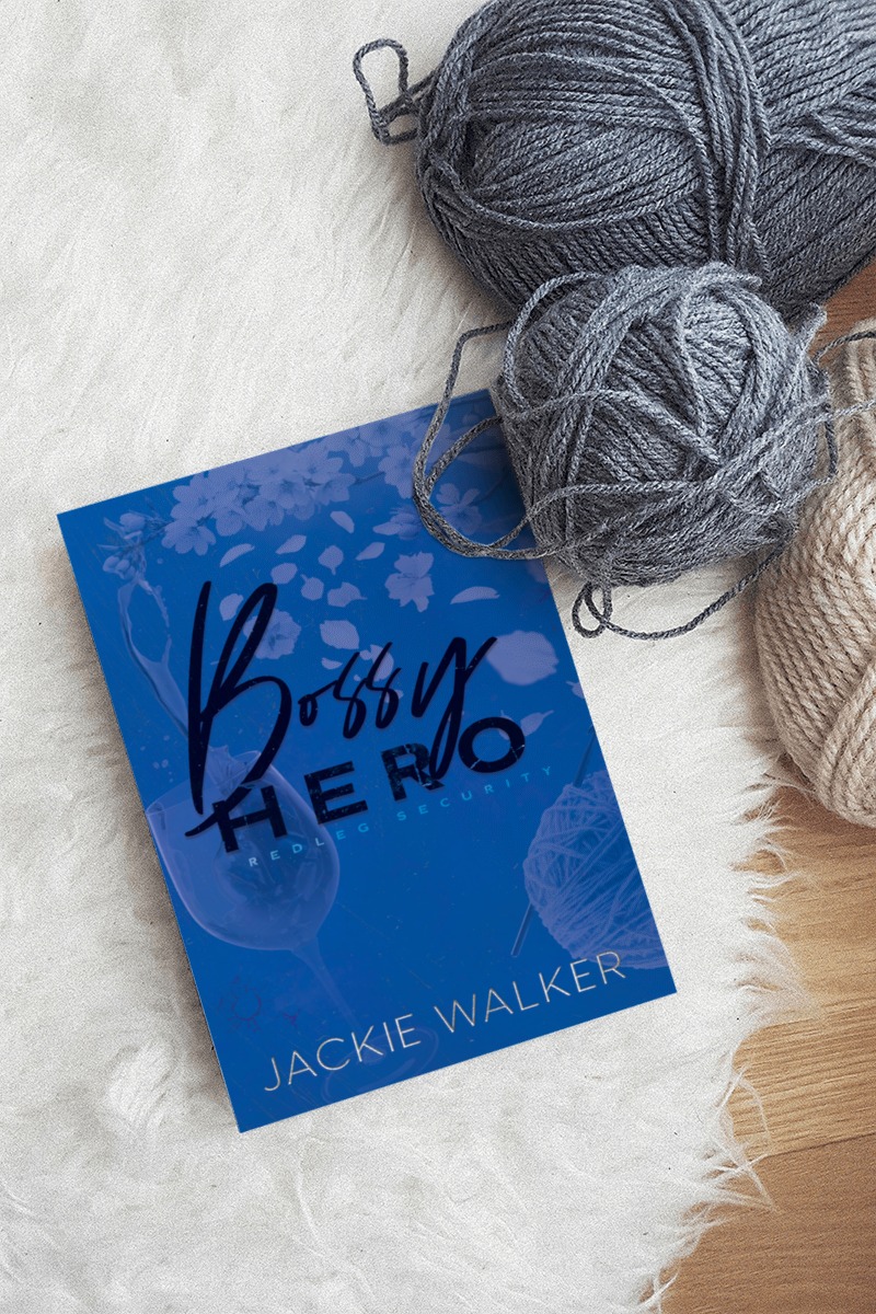 Blue Bossy Hero discrete cover on a white furry rug with gray and beige balls of yarn.